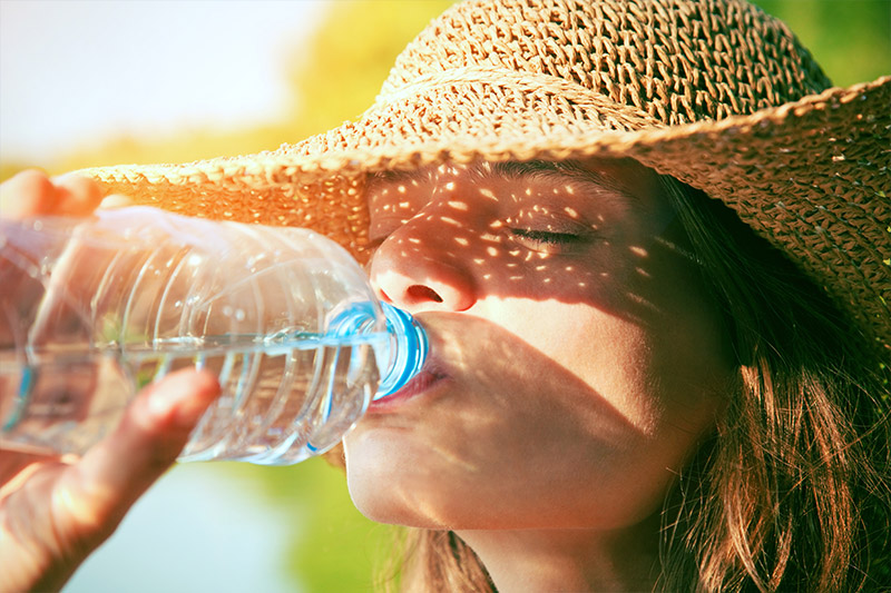 Woman in Hat Drinking Water