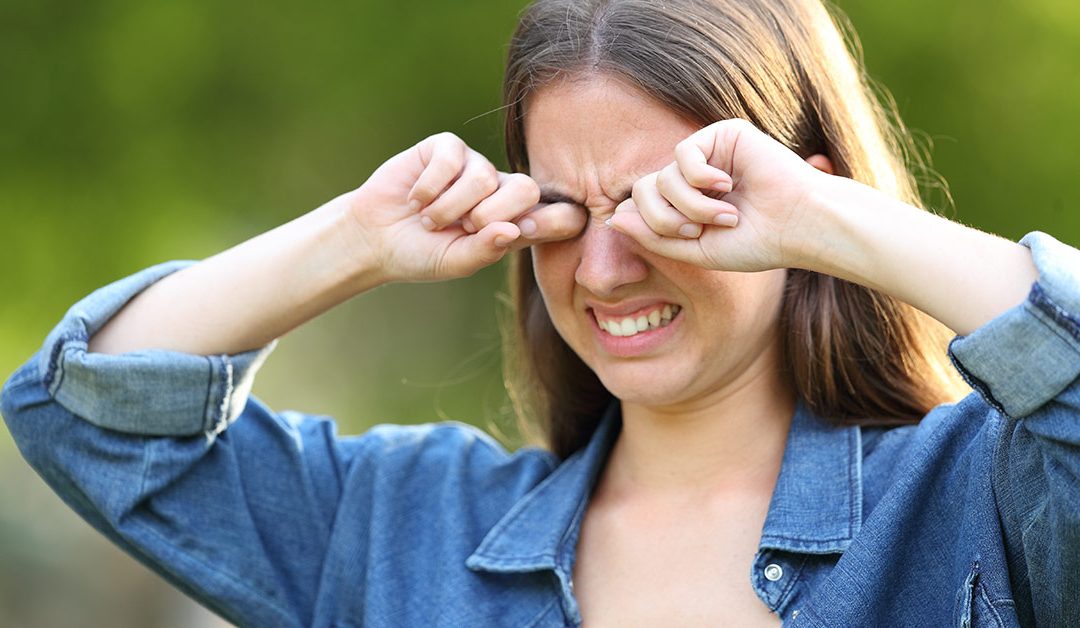 Woman rubbing eyes outdoors